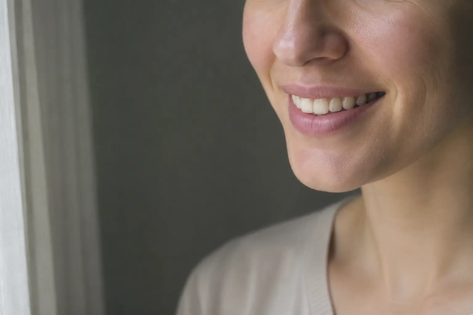 Fictional adult with a natural relaxed smile in real window light, shown without before-and-after framing